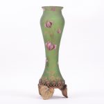 Art nouveau glass vase with metal legs.
